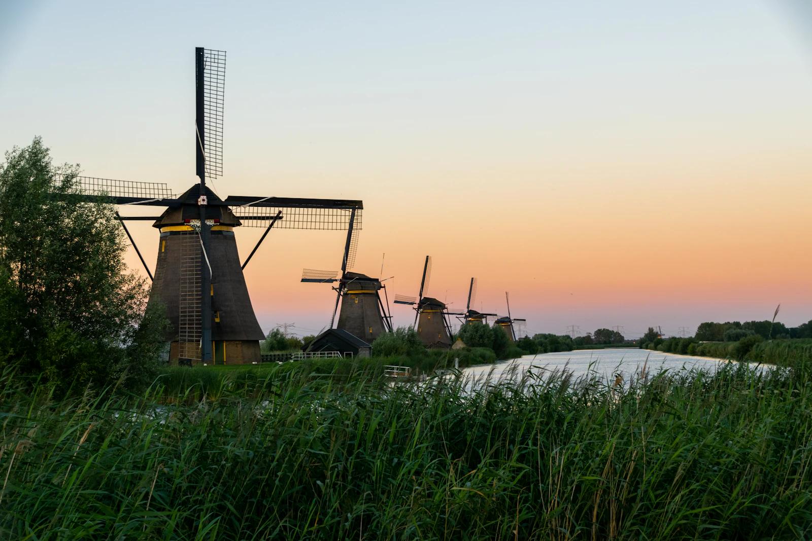 Moinhos de vento ao longo de um canal em Kinderdijk, nos Países Baixos, na hora dourada