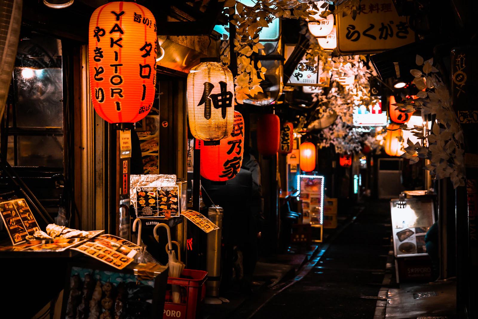 Beco estreito de Shinjuku, em Tóquio, à noite, com lanternas vermelhas de papel e pequenos bares