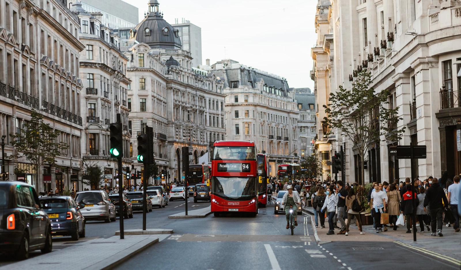 Ônibus vermelho de dois andares numa rua movimentada de Londres, trafegando pela esquerda
