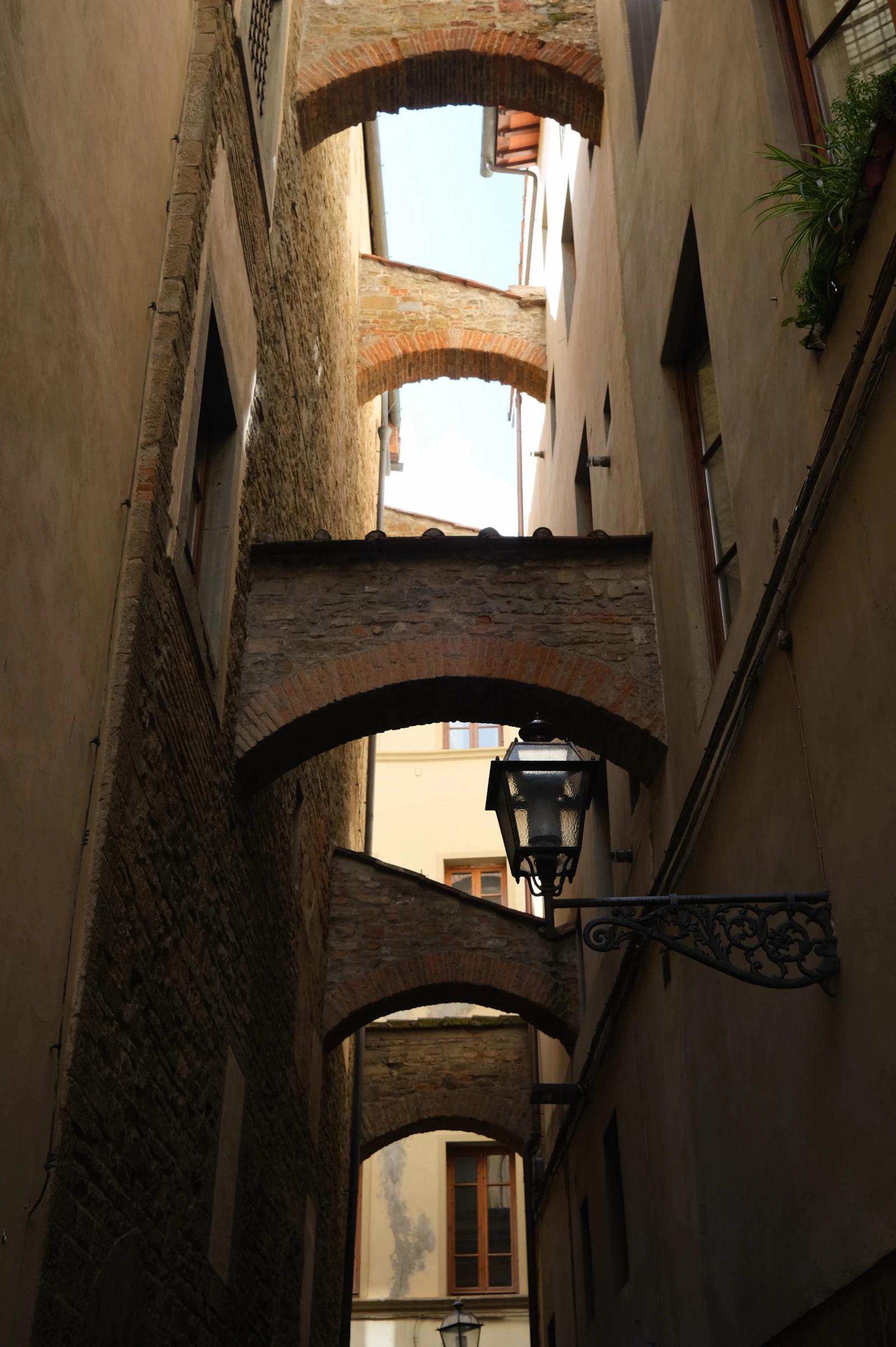 Arcos ligando prédios sobre uma viela estreita no centro de Florença