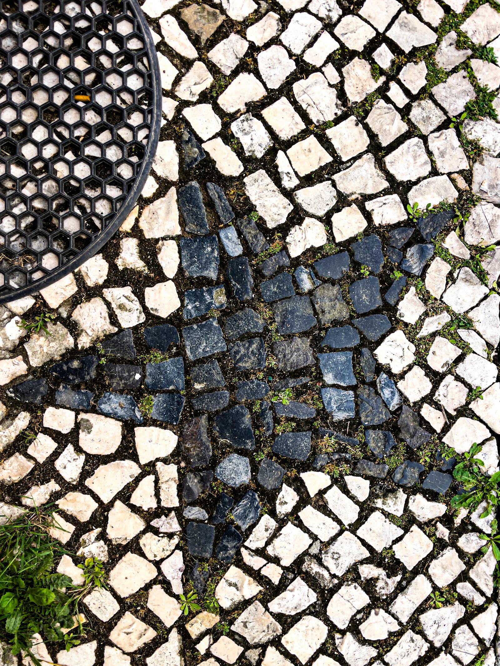 Padrão de estrelas em pavimento de pedra numa calçada de Lisboa